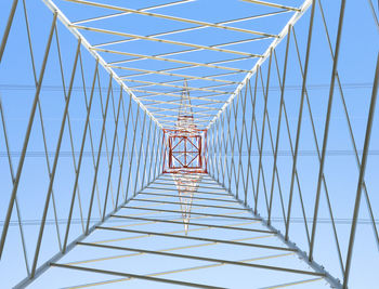 Electricity pylon high tension in perspective seen from below with blue sky background