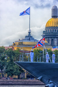 View of flags at dock against cloudy sky