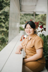 Portrait of a smiling young woman sitting outdoors