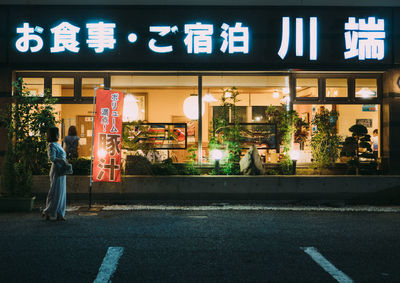 People on illuminated street at night