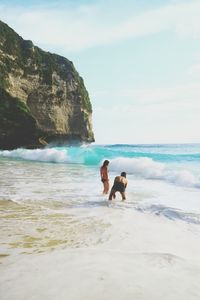 Men on beach against sky