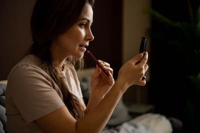 Woman applying lipstick