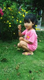 Cute girl with pink flower on field