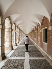 Rear view of man walking in tunnel
