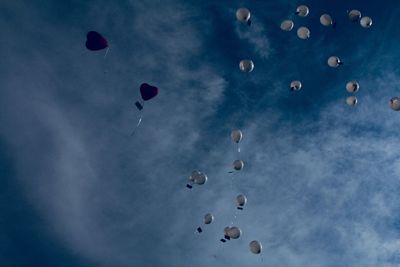 Low angle view of balloons flying in blue sky