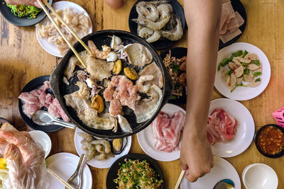 Bbq barbecue eating. people grilling  pork, meal, shellfish and shrimp with wooden chopsticks.