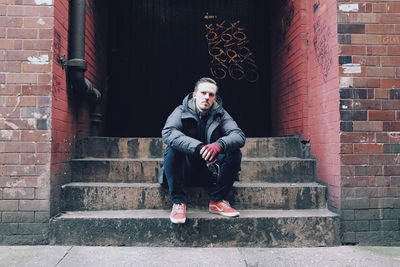 Portrait of young man standing on wall