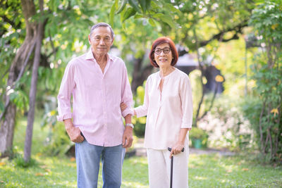 Portrait of smiling senior couple standing at park