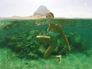 Portrait of young woman swimming in sea