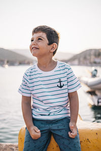 Cute kid smiling at sunset with the sea in the background