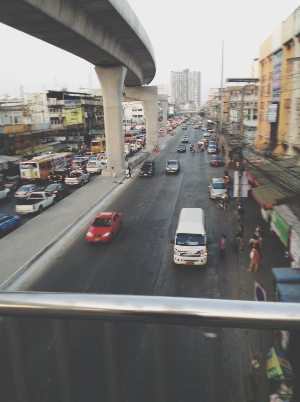 transportation, city, mode of transport, car, architecture, built structure, land vehicle, building exterior, street, public transportation, road, traffic, city life, travel, on the move, incidental people, clear sky, city street, railroad track, day