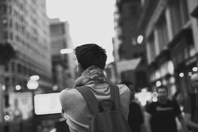 Rear view of man standing on street at night