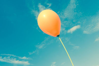 Low angle view of balloons against blue sky