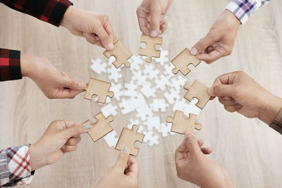 Cropped image of man holding jigsaw piece