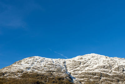 Low angle view of mountain against clear blue sky