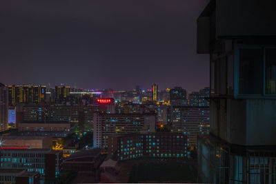 Illuminated cityscape against clear sky at night