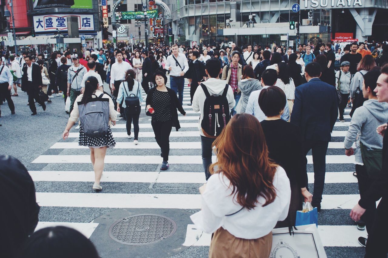 large group of people, person, men, lifestyles, street, walking, city life, leisure activity, crowd, city, medium group of people, mixed age range, rear view, casual clothing, market, standing, shopping, group of people, city street