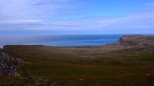 View of calm blue sea against cloudy sky