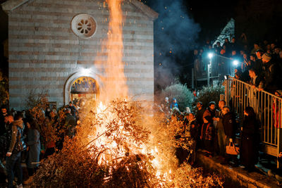 Rear view of people walking on street at night