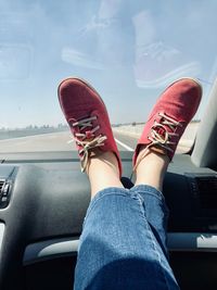 Low section of woman on dashboard in car