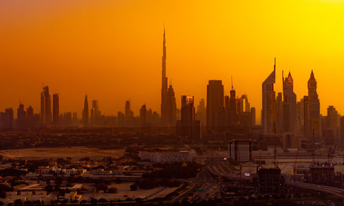 Modern buildings in city against clear sky during sunset