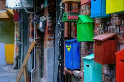 Multi colored mailboxes on brick wall of residential building