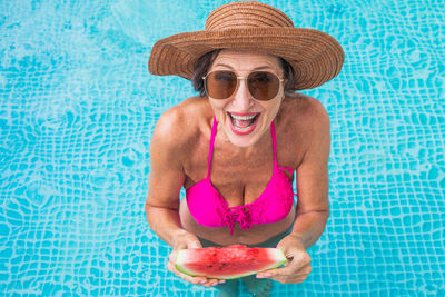 Portrait of young woman wearing hat against swimming pool