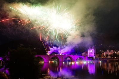 Firework display over river at night