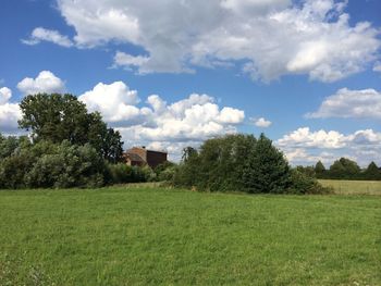 Scenic view of grassy field against cloudy sky