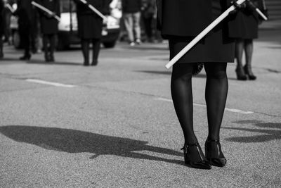 Low section of women standing on road in city