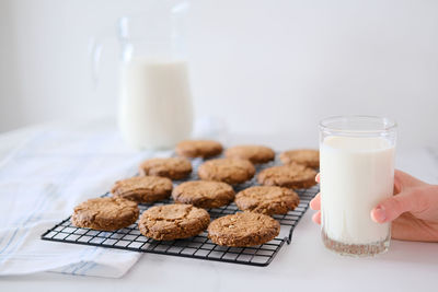 Delicious homemade cookies on a drying rack and a glass of milk