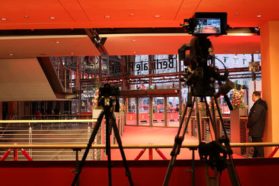 Full length of woman photographing in illuminated room