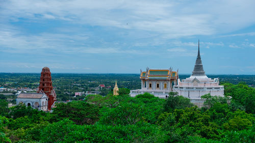 Panoramic view of buildings and trees against sky