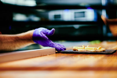 Close-up of hand holding food on table