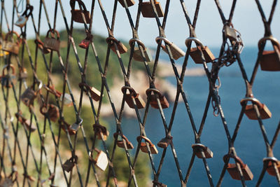 Full frame shot of fence with padlocks against lake