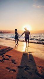 Couple walkig towards sunset in beach