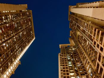 Low angle view of illuminated buildings against sky at night