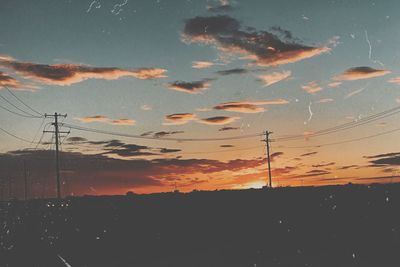 Silhouette electricity pylon against sky during sunset