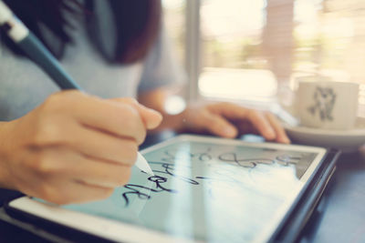 Midsection of man using smart phone on table