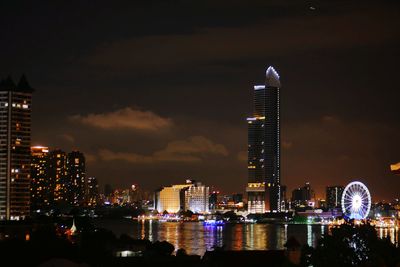 Illuminated buildings against sky at night