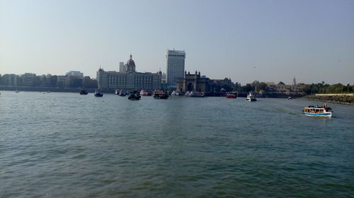 Boats in sea against buildings in city