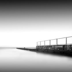 Pier by sea against sky during foggy weather