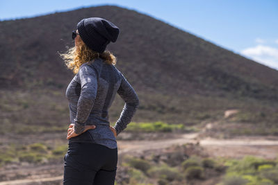 Rear view of woman wearing hat while standing on land