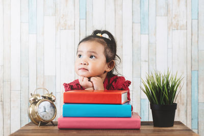 Portrait of cute girl sitting on table