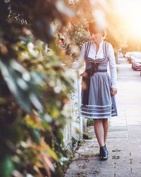 Full length of woman walking on footpath in city