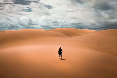 Full length of man standing on sand dune