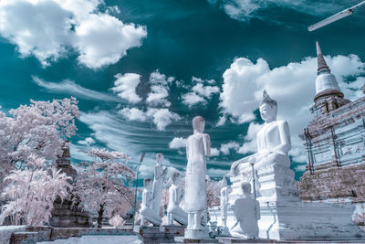 Statue by trees and building against sky