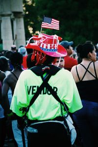 Rear view of street vendor wearing american flag on hat in park