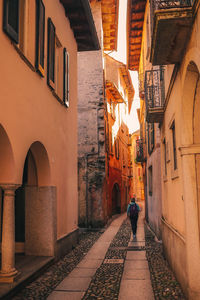 Rear view of woman walking in alley