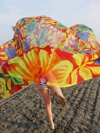 Close-up of person running on beach with scarf